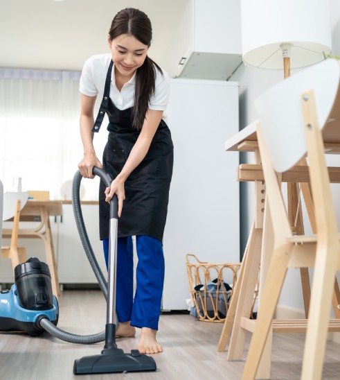 Femme passe l'aspirateur chez elle